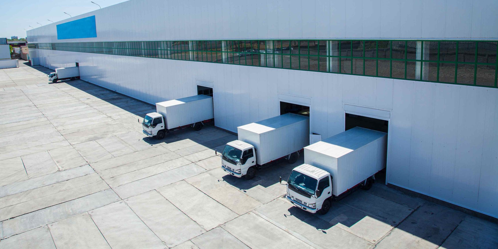 Four trucks coming out of a warehouse.