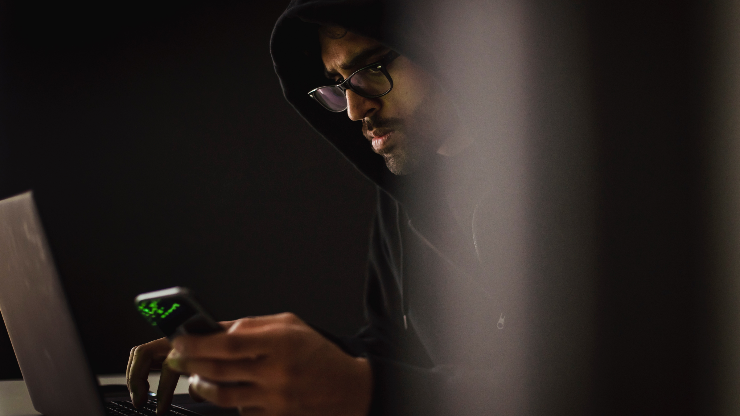 A man working on his computer and phone.